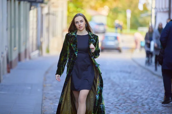穿着绿色外套的年轻貌美的女人走在城市里 — 图库照片