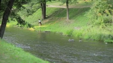 a young girl with dog walking near river