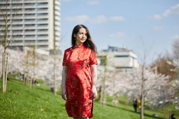 Όμορφη Νεαρή Γυναίκα Ένα Κόκκινο Φόρεμα Ποζάρουν Στο Πάρκο — Φωτογραφία Αρχείου