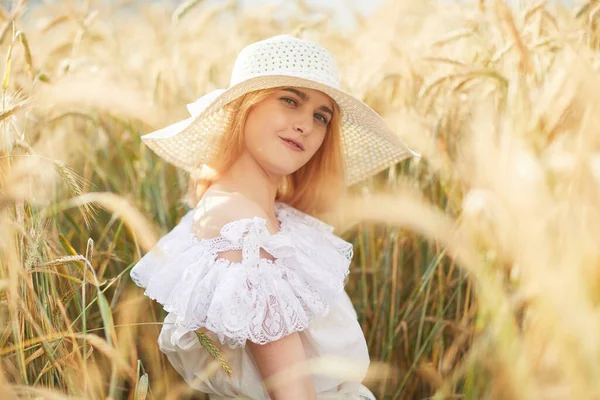 밭에서 카메라에 포즈를 취하고 모자를 여자의 — 스톡 사진