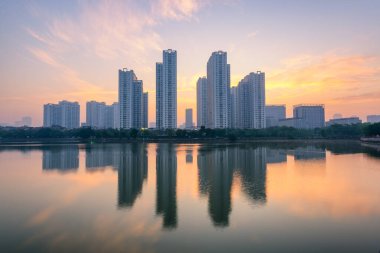 Hanoi 'deki An Binh City' de gün batımında gölde yansıyan binalar. Gün doğumunda Hanoi şehir manzarası