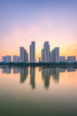 Hanoi 'deki An Binh City' de gün batımında gölde yansıyan binalar. Gün doğumunda Hanoi şehir manzarası