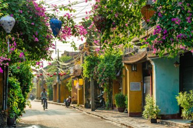 Hoi An, Vietnam - 16 Temmuz 2024: Trafik sabahı, dekore edilmiş ipek fenerler, inanılmaz geleneksel sarı evler. Tarihi eski Hoi An kasabası 1999 yılından bu yana UNESCO 'nun Dünya Mirası Alanında yer alıyor..