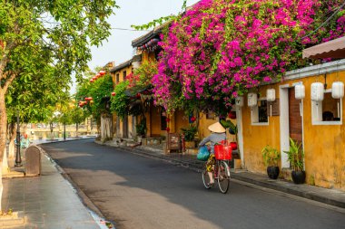 Hoi An, Vietnam - 16 Temmuz 2024: Trafik sabahı, dekore edilmiş ipek fenerler, inanılmaz geleneksel sarı evler. Tarihi eski Hoi An kasabası 1999 yılından bu yana UNESCO 'nun Dünya Mirası Alanında yer alıyor..