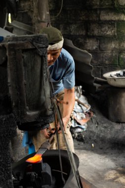 Cao Bang Province, Vietnam - February 24, 2024: Blacksmith makes a traditional rural knife in Cao Bang province, Vietnam clipart