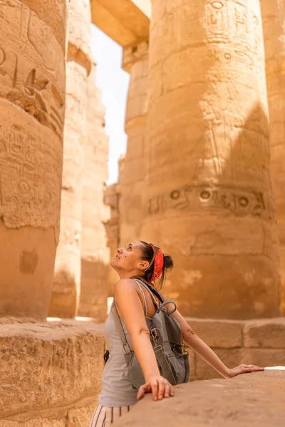 Karnak 'ta Mısır arkeolojik kalıntıları tasarlayan beyaz bir turistin dikey fotoğrafı.