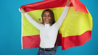 Mutlu bir Afrikalı kadının İspanyol bayrağı çekerken çekilmiş mavi arkaplan videosu.