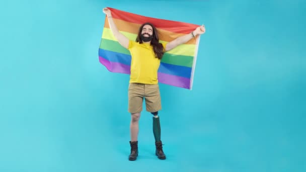 Studio Portrait Blue Background Smiley Man Prosthetic Leg Waving Rainbow — Stok video