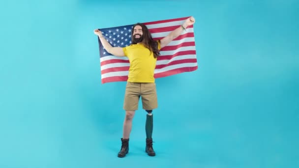 Студійний Портрет Синім Тлом Гордого Чоловіка Протезною Ногою Піднімає Північноамериканський — стокове відео