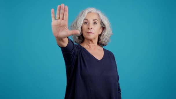 Studio Video Blue Background Serious Mature Woman Gesturing Her Hand — Stock Video