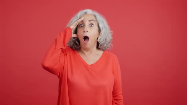 Studio Video Red Background Mature Woman Looking Camera Surprised Look — Vídeo de Stock