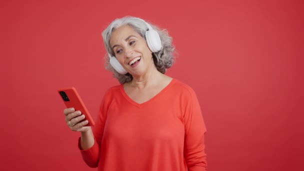 Studio Video Red Background Happy Mature Woman Dancing Listening Music — Stockvideo
