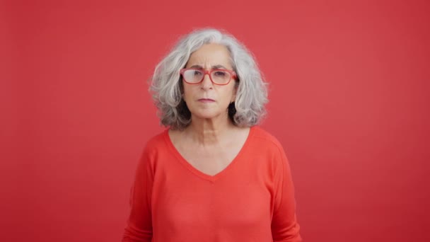 Studio Video Red Background Mature Woman Lifting Her Glasses Looking — Vídeo de Stock