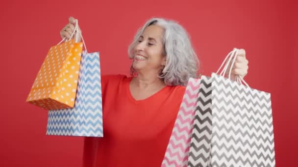Studio Video Red Background Happy Mature Woman Standing Showing Shopping — Stok video