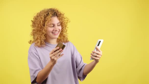 Studio Video Yellow Background Smiley Woman Curly Hair Using Card — Vídeo de Stock