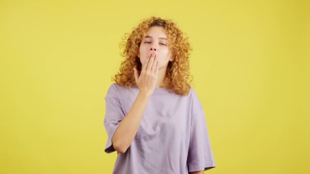 Студійне Відео Жовтим Тлом Молодої Жінки Кучерявим Волоссям Дме Поцілунок — стокове відео