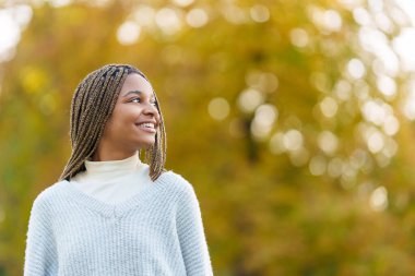 Photo with copy space of a distracted african woman looking up in a park