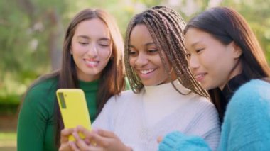 Slow motion video with travelling of happy multiethnic friends having fun using the mobile outdoors