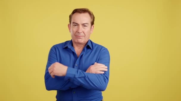 Mature Man Standing Looking Camera Arms Crossed Studio Yellow Background — Stockvideo