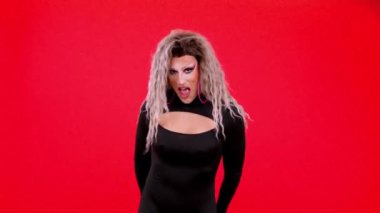 Happy transgender person dressed as drag queen smiling at camera while giving a gift