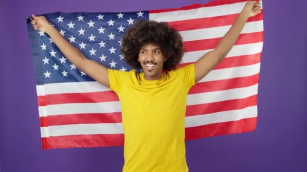 Счастливый Африканский Мужчина Поднимает Национальный Флаг Северной Америки Глядя Камеру — стоковое видео