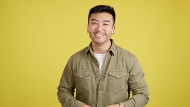 中国語男笑いと見てカメラでスタジオで黄色の背景 — ストック動画