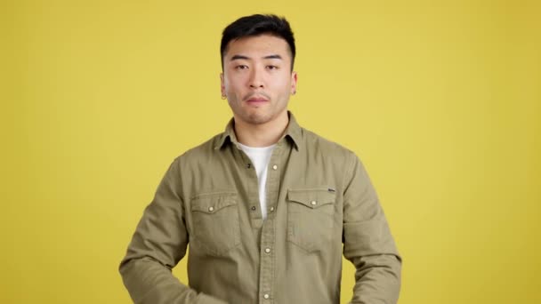 Serious Chinese Man Standing Crossed Arms Looking Camera Studio Yellow — Stockvideo