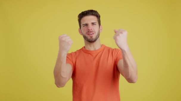 Щасливий Білий Чоловік Святкує Під Час Виховання Кулаків Студії Жовтим — стокове відео