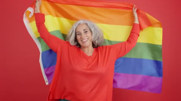 Студійне Відео Червоним Тлом Щасливої Жінки Махає Веселковим Прапором Lgbt — стокове відео