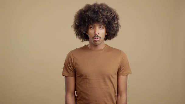 Африканский Мужчина Вьющимися Волосами Смотрит Камеру Грустным Выражением Лица Студии — стоковое видео