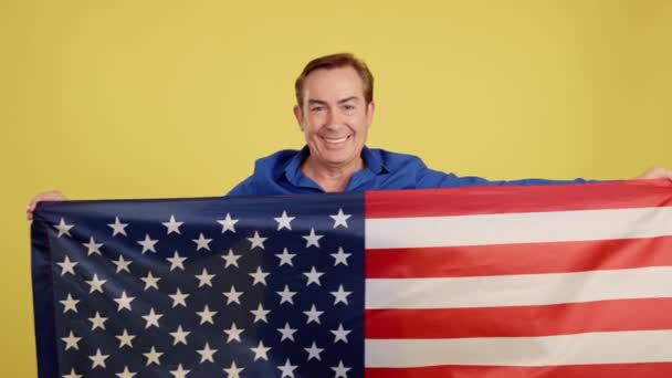 Χαμογελαστή Και Ευτυχισμένη Ώριμη Καυκάσιος Άνδρας Υψώνοντας Μια Εθνική Σημαία — Αρχείο Βίντεο