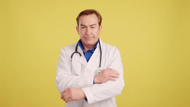 Serious Caucasian Doctor Looking Camera Arms Crossed Studio Yellow Background — Vídeos de Stock