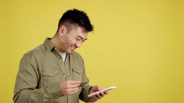 Happy Chinese Man Using Mobile Card Shopping Online Studio Yellow — Stockvideo
