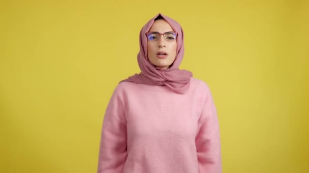 Мусульманская Женщина Снимает Очки Увидеть Студии Желтым Фоном — стоковое видео