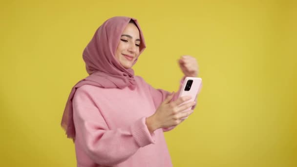 Mujer Musulmana Emocionada Celebrando Levantar Puño Mientras Usa Móvil Estudio — Vídeo de stock