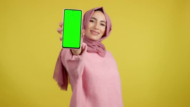 Zielony Ekran Telefonu Komórkowego Posiadanego Przez Muzułmankę Studio Żółtym Tłem — Wideo stockowe