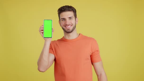 Happy Caucasian Man Holding Mobile Chroma Screen Studio Yellow Background — Stok video