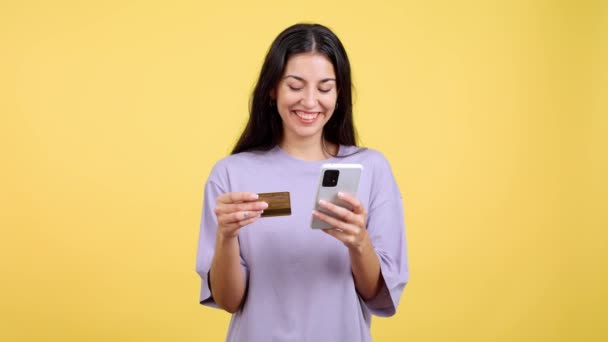 Happy Woman Using Mobile Card Shopping Online Studio Yellow Background — Vídeo de Stock