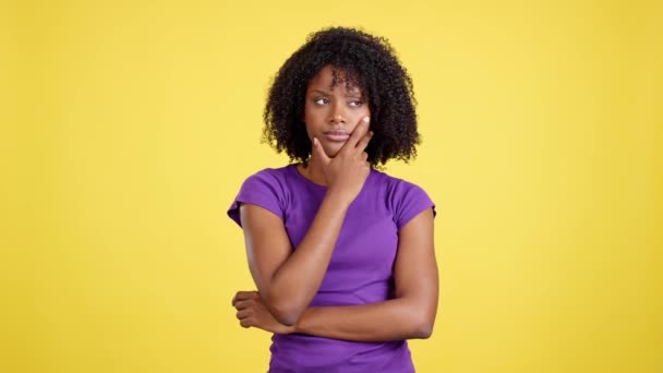 Женщина Афро Волосами Стоящая Вдумчивым Выражением Лица Студии Желтым Фоном — стоковое видео