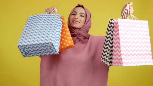 Muslim Woman Smiling Camera While Showing Shopping Bags Studio Yellow — Video