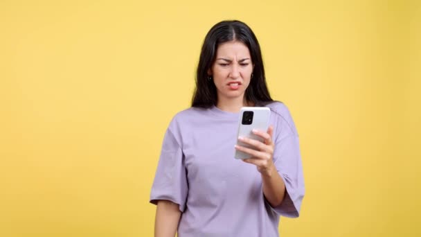 Занепокоєна Біла Жінка Використовує Мобільний Телефон Студії Жовтим Тлом — стокове відео