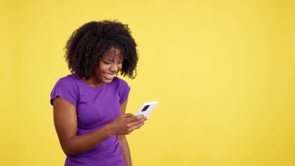 Happy Woman Afro Hair Smiling While Reading Mobile Studio Yellow — Vídeo de Stock