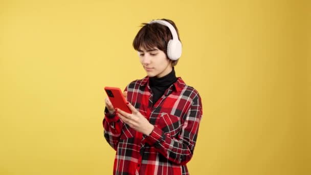 Happy Androgynous Person Listening Music Mobile Headphones Studio Yellow Background — Stok video