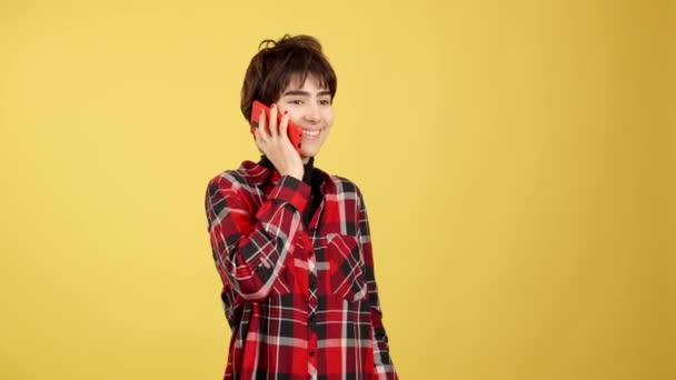 Happy Androgynous Person Talking Mobile Studio Yellow Background — Stockvideo