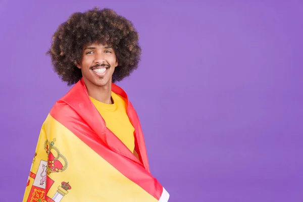 Африканський Чоловік Посміхається Перед Камерою Обгортаючи Іспанським Прапором Студії — стокове фото