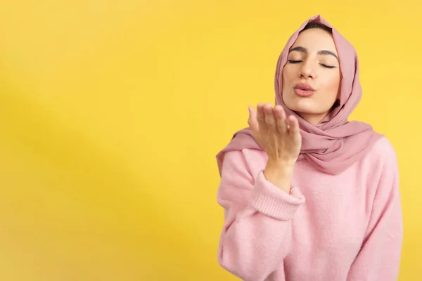Muslim Woman Blowing Kiss Eyes Closed Studio Yellow Background — Stock Photo, Image