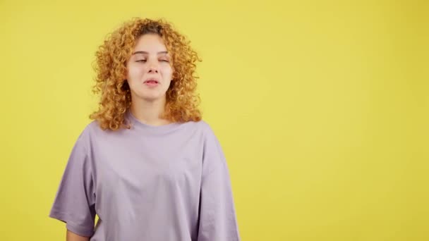 Studio Video Žlutým Pozadím Mladé Ženy Kudrnatými Vlasy Ukazuje Překvapeně — Stock video