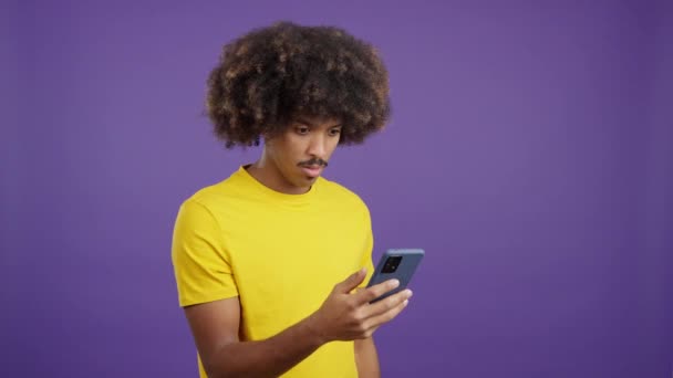 Здивований Африканський Чоловік Кучерявим Волоссям Дивиться Екран Мобільного Студії — стокове відео