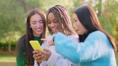 Üç mutlu çoklu etnik arkadaşın açık havada eğlenirken ki yavaş çekim videosu.