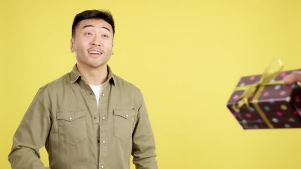 Happy Chinese Man Smiling While Receiving Gift Studio Yellow Background — Stock Video